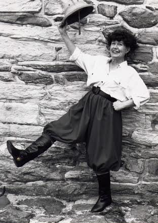 Barbara Mertz waving a pith hat cheerfully